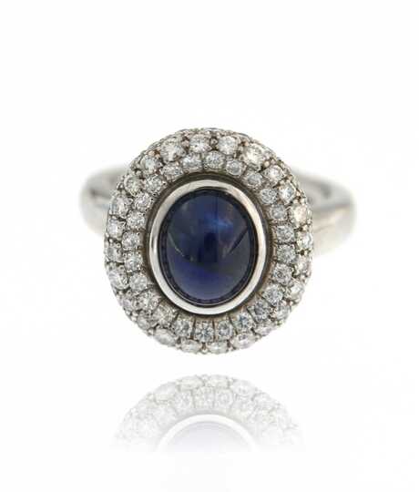 White gold ring with oval sapphire cabochon and diamonds