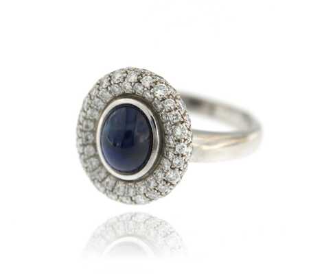 White gold ring with oval sapphire cabochon and diamonds