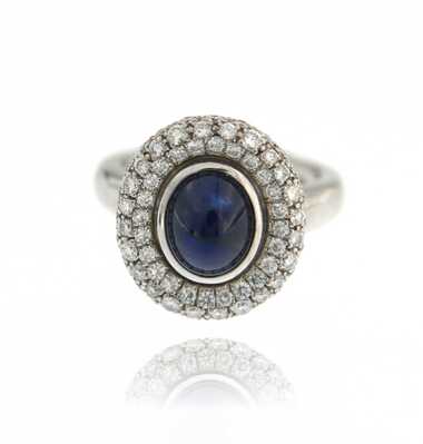 White gold ring with oval sapphire cabochon and diamonds