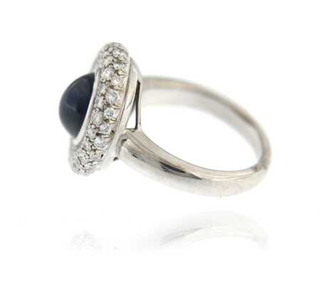 White gold ring with oval sapphire cabochon and diamonds