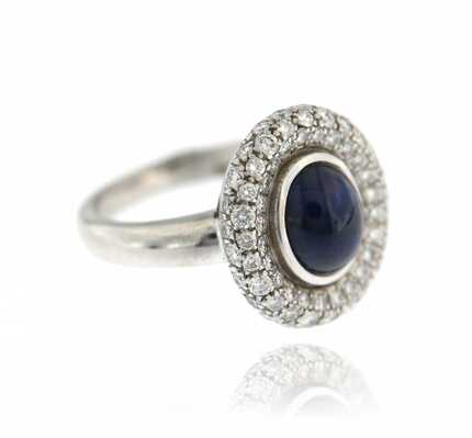 White gold ring with oval sapphire cabochon and diamonds